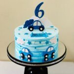 Blue cake with car and number 6 topper.