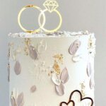 Lavender petal cake with gold ring topper.
