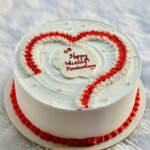 Minimalist white cake with red heart piping.