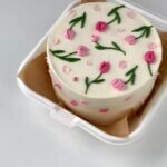 White bento cake pink tulip green leaves buttercream floral Karachi