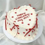 Heart shaped cake with red ribbons.