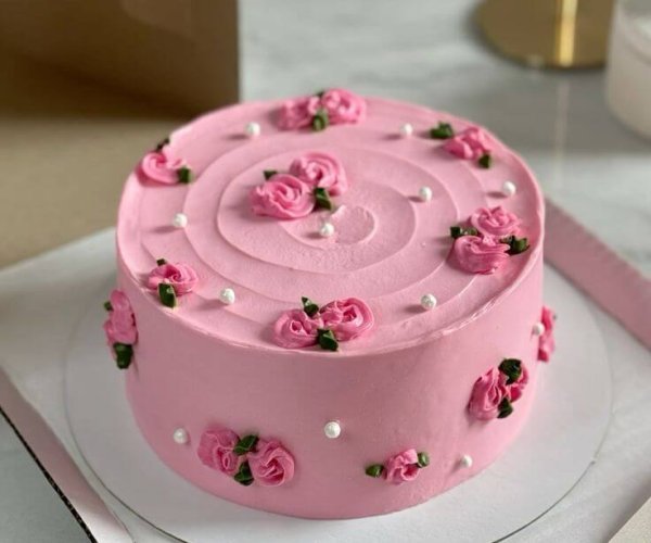 Pink buttercream rose cake white pearls green leaves custom Karachi
